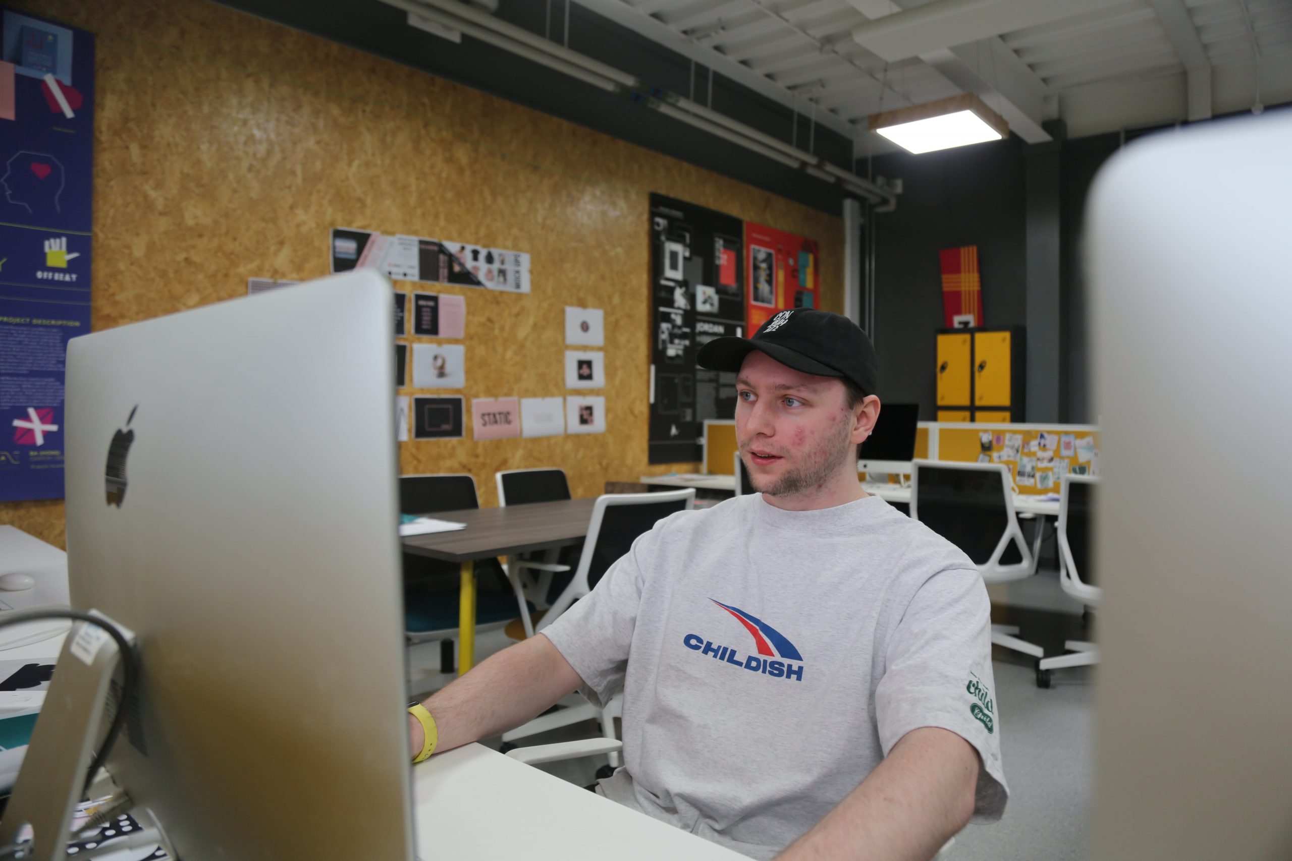 Man looks at mac book screen in art studio
