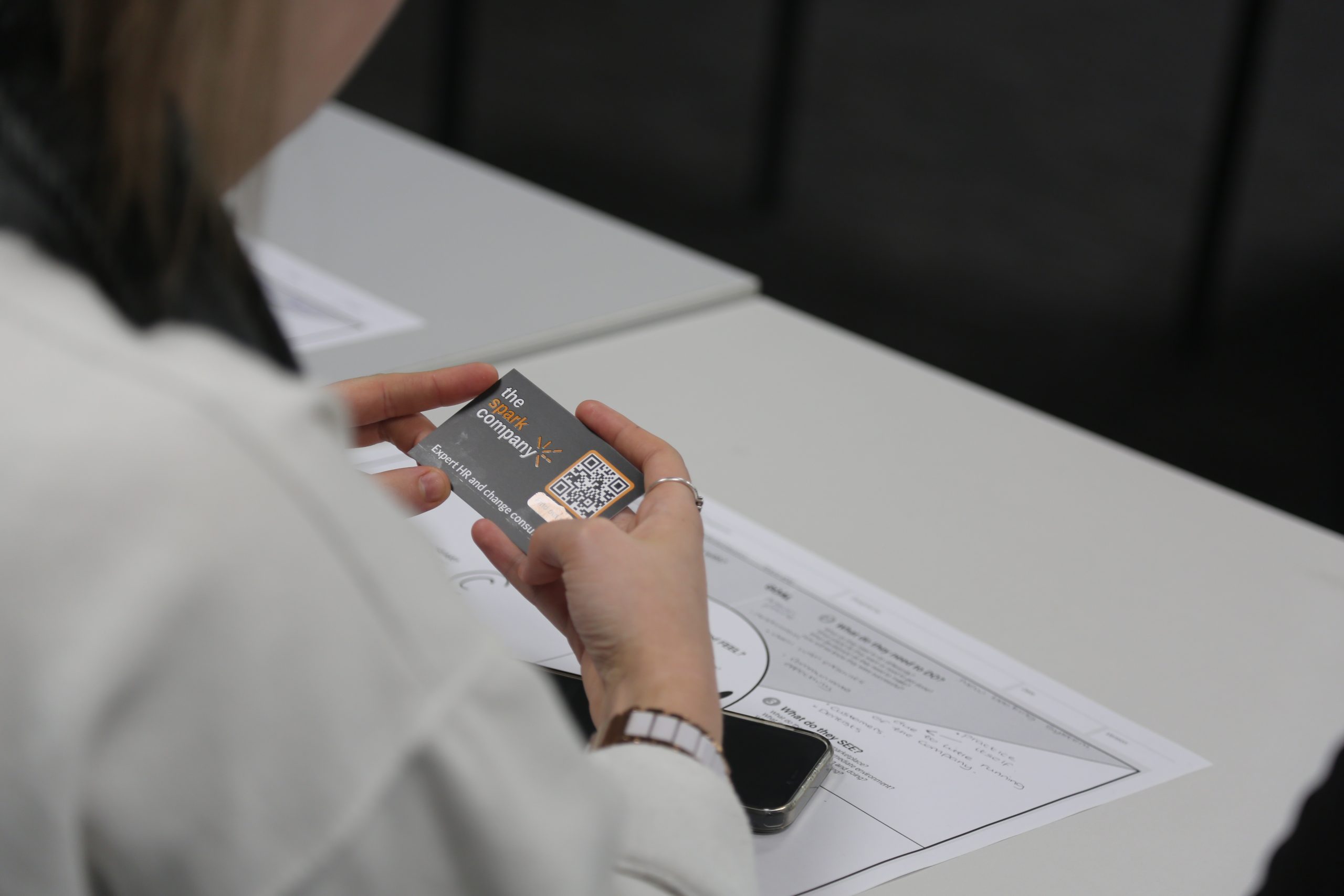 Business student holding the Spark Company business card