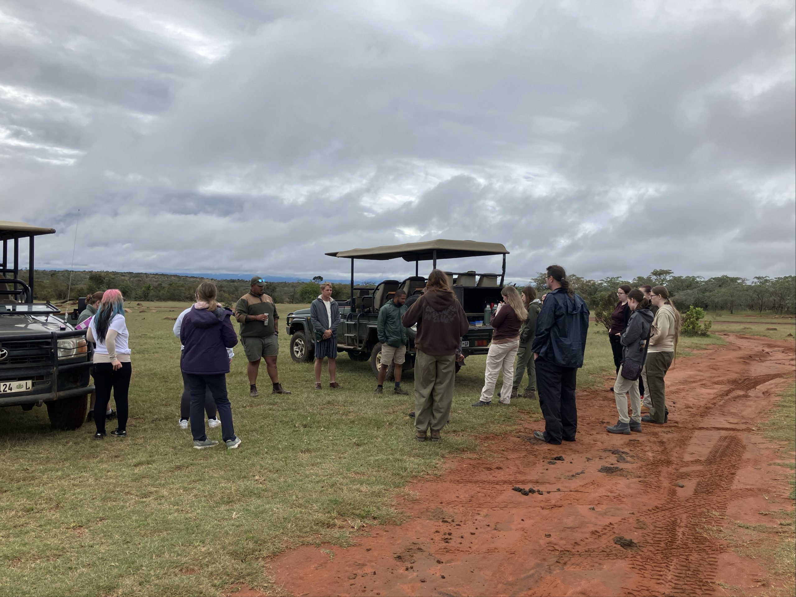 Students at the boma, having an explanation by the vehicles.