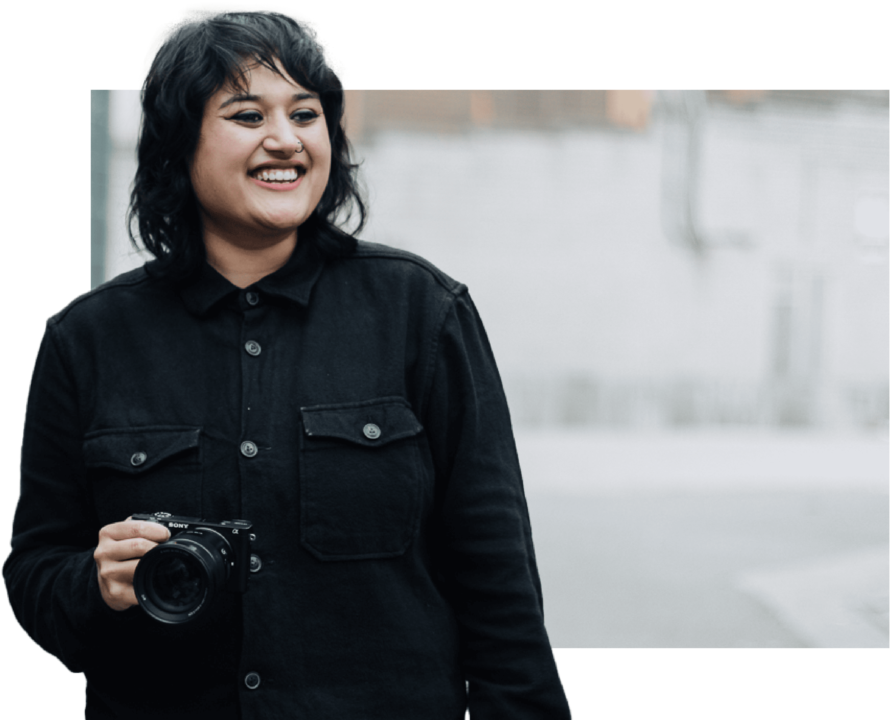 Female media student holding camera with a photoshopped background