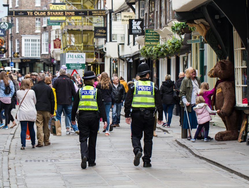 Policeman and Policewoman walking through a busy high street