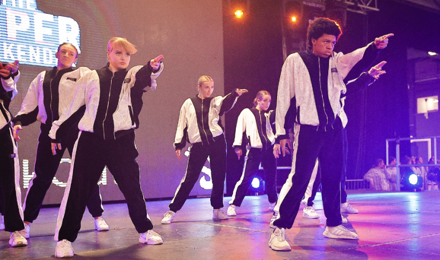Dances for Commercial Performance students dancing on stage wearing tracksuits on stage in weston super mare