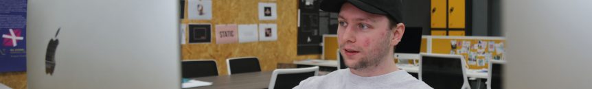 Man looks at mac book screen in art studio