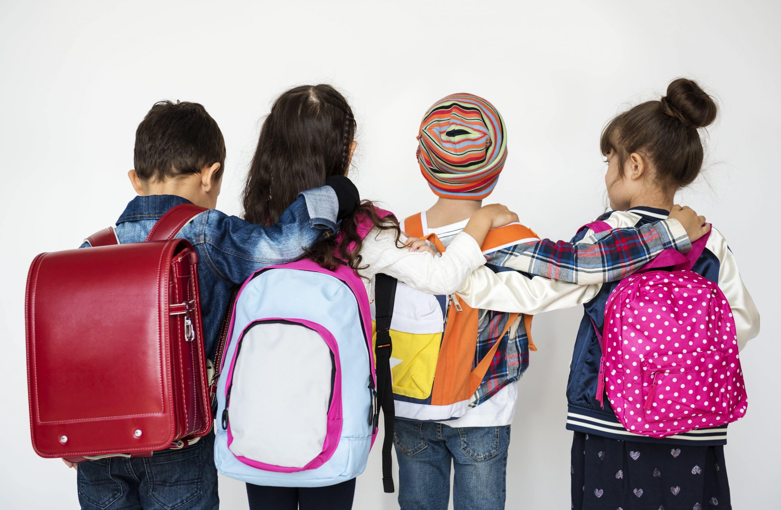 Young students with backpacks linking shoulders