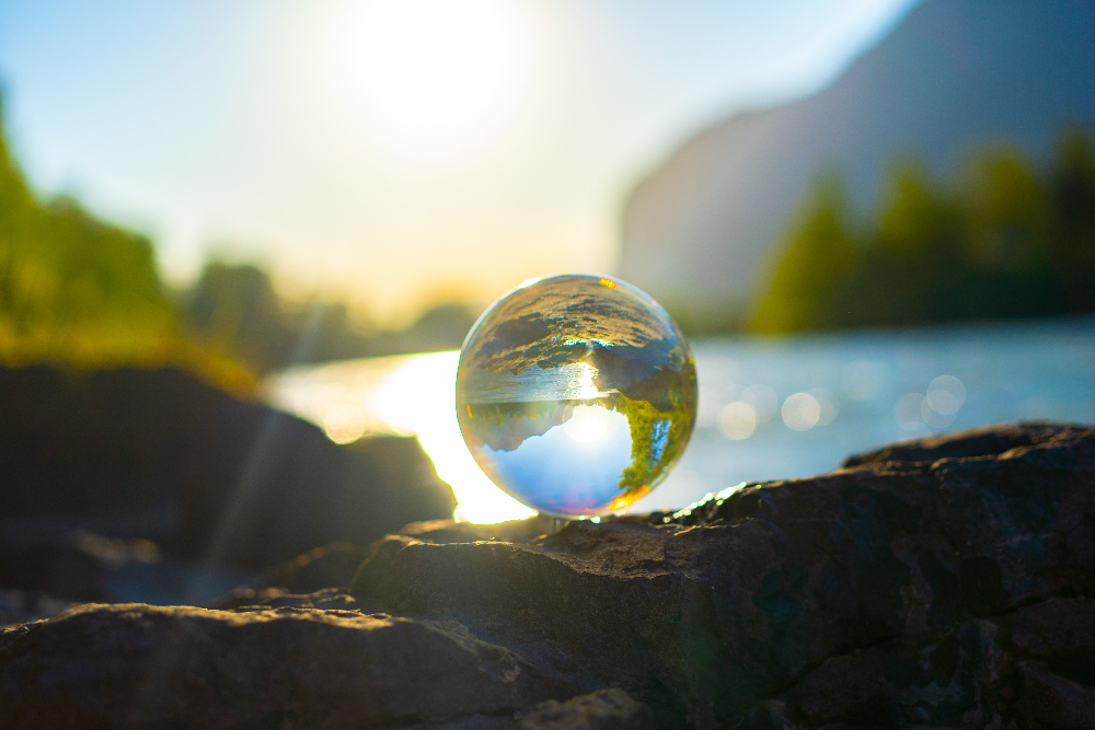 Water droplet in focus with lake and trees blurred in background