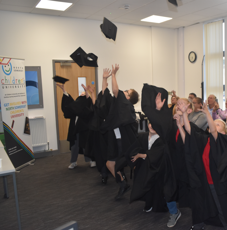 Children's University children throwing graduation caps into air