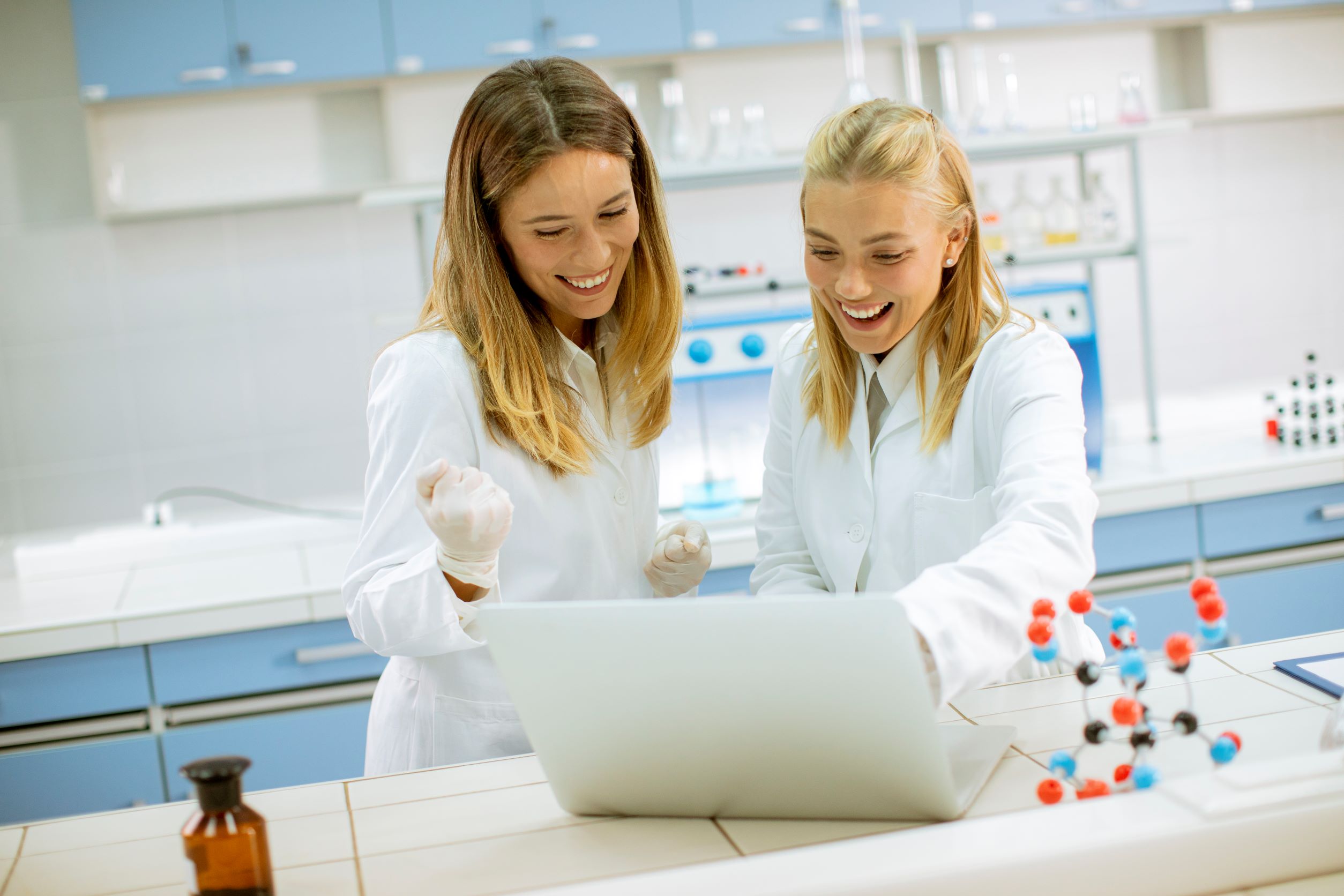 Female students in white lab coats discussing top 10 Bio Lab careers