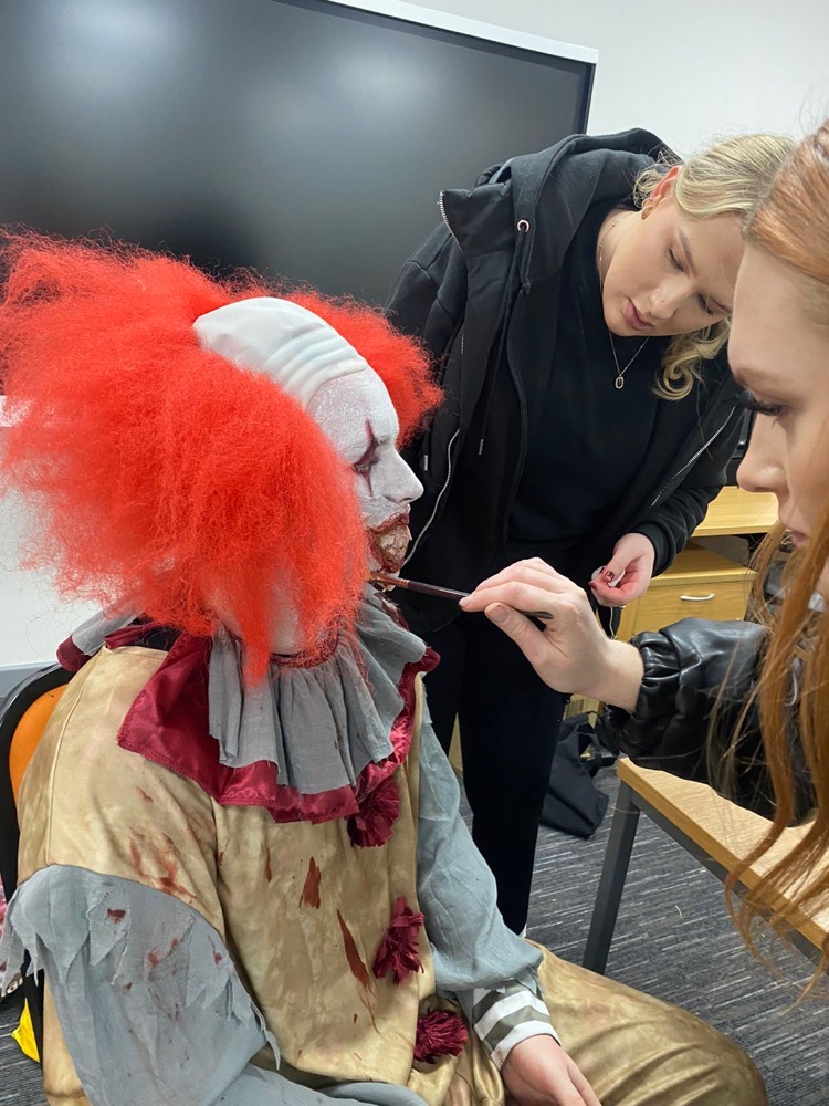 Hair, Make-Up & Prosthetics for Production students creating clown halloween make-up on an actor
