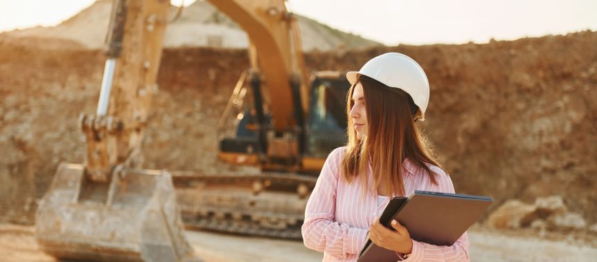 young woman with documents in hard hat