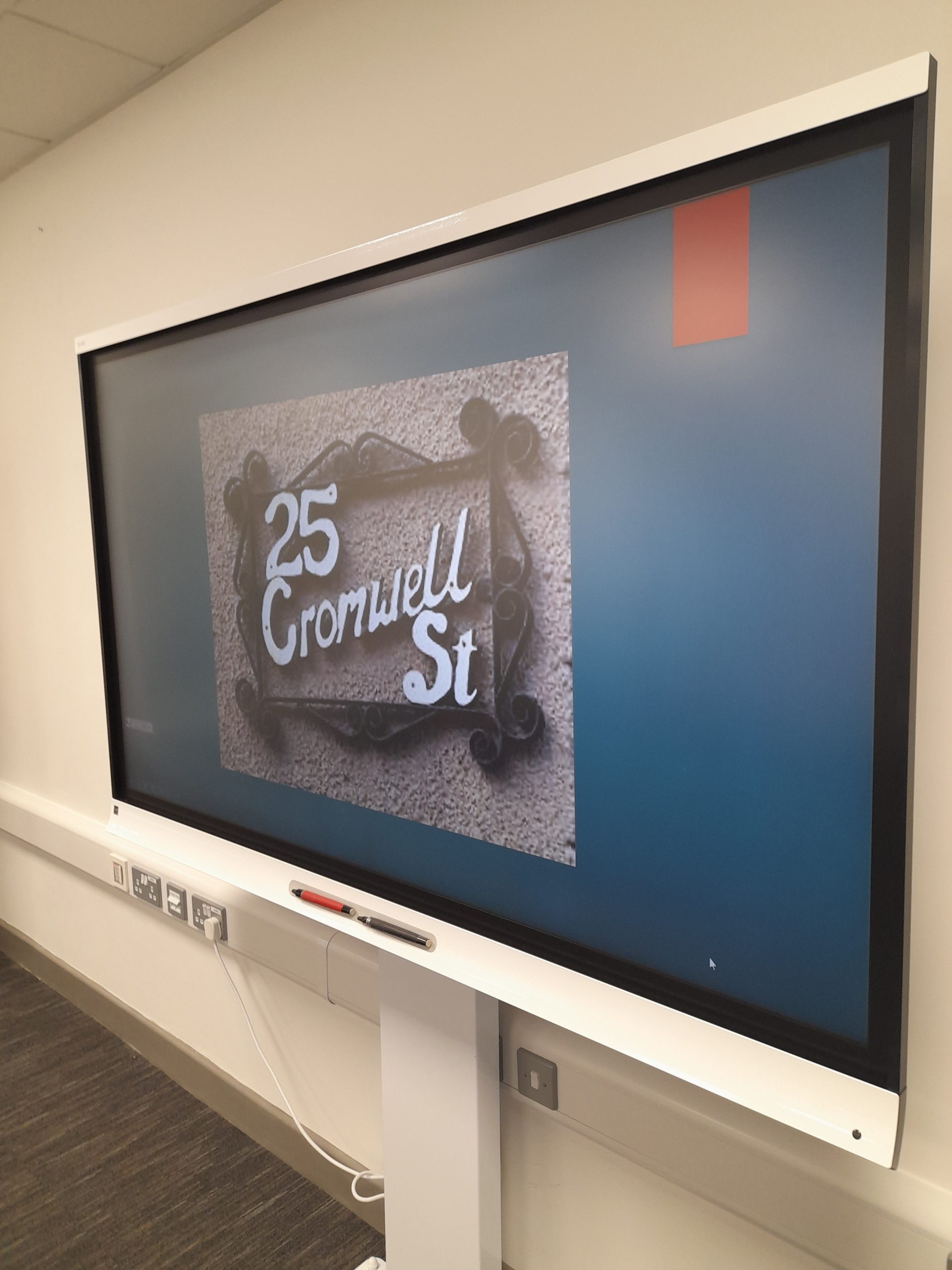 Interactive board showing presentation for Uniformed Public Services students - slide with photo of '25 Cromwell St.' sign