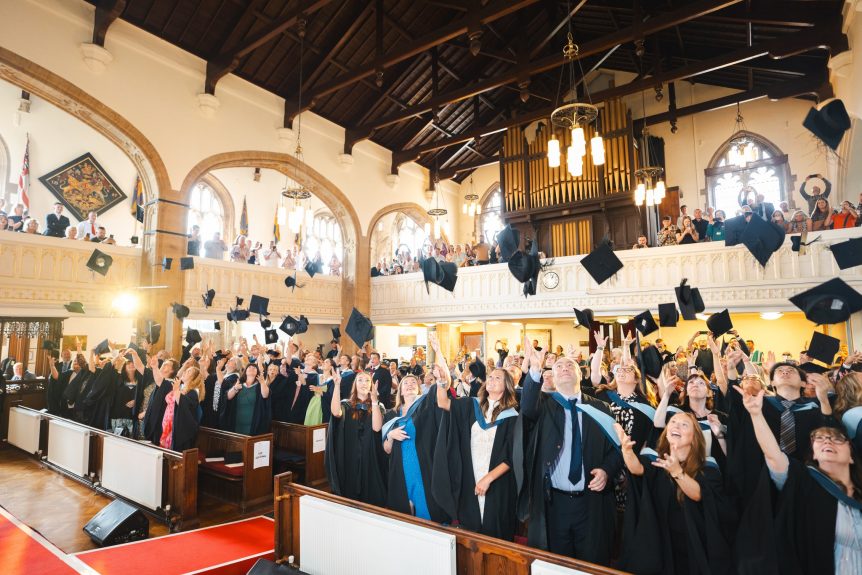 Students throwing mortarboards in the air