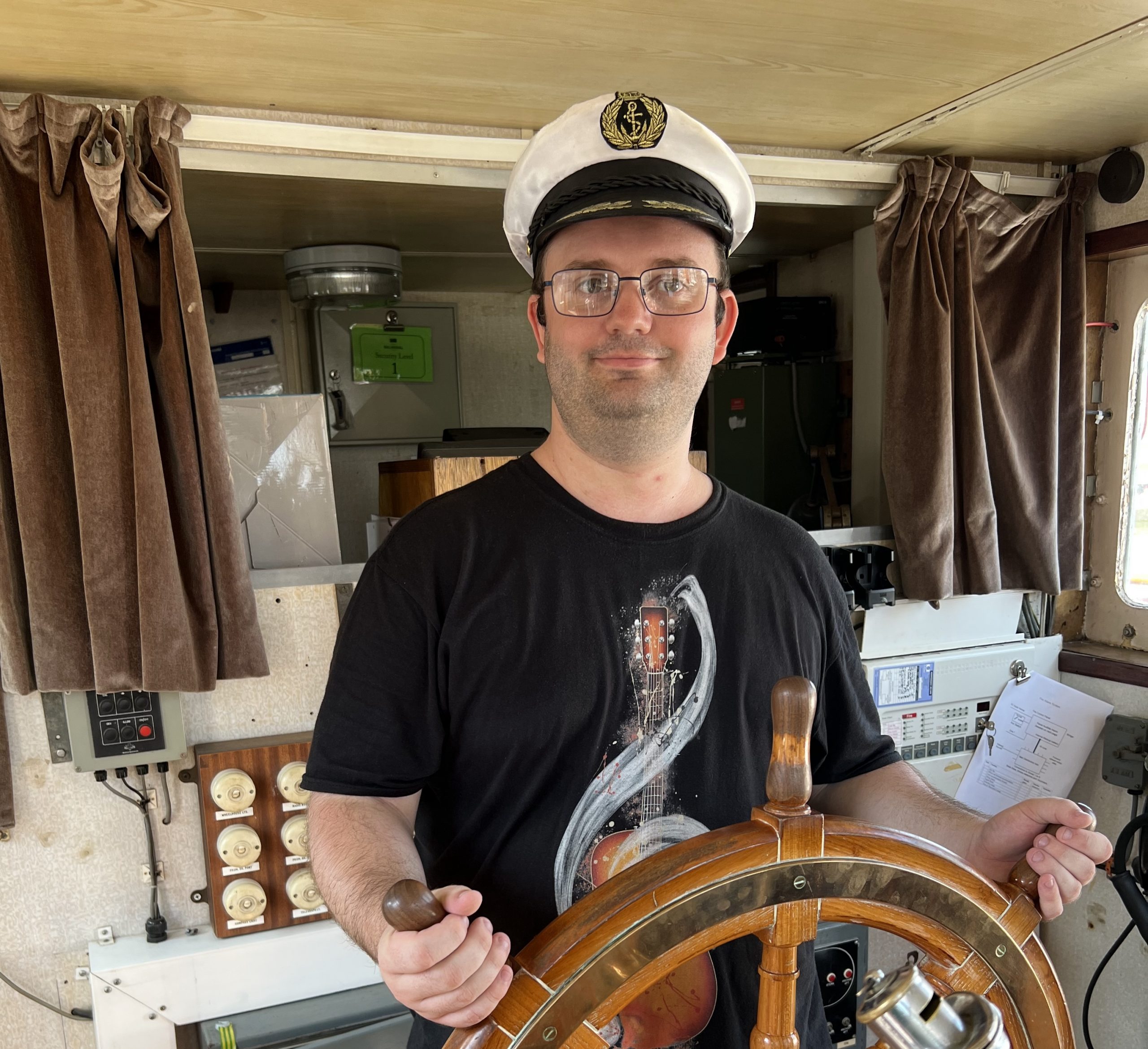 karl steering a ship wheel in a sailors hat