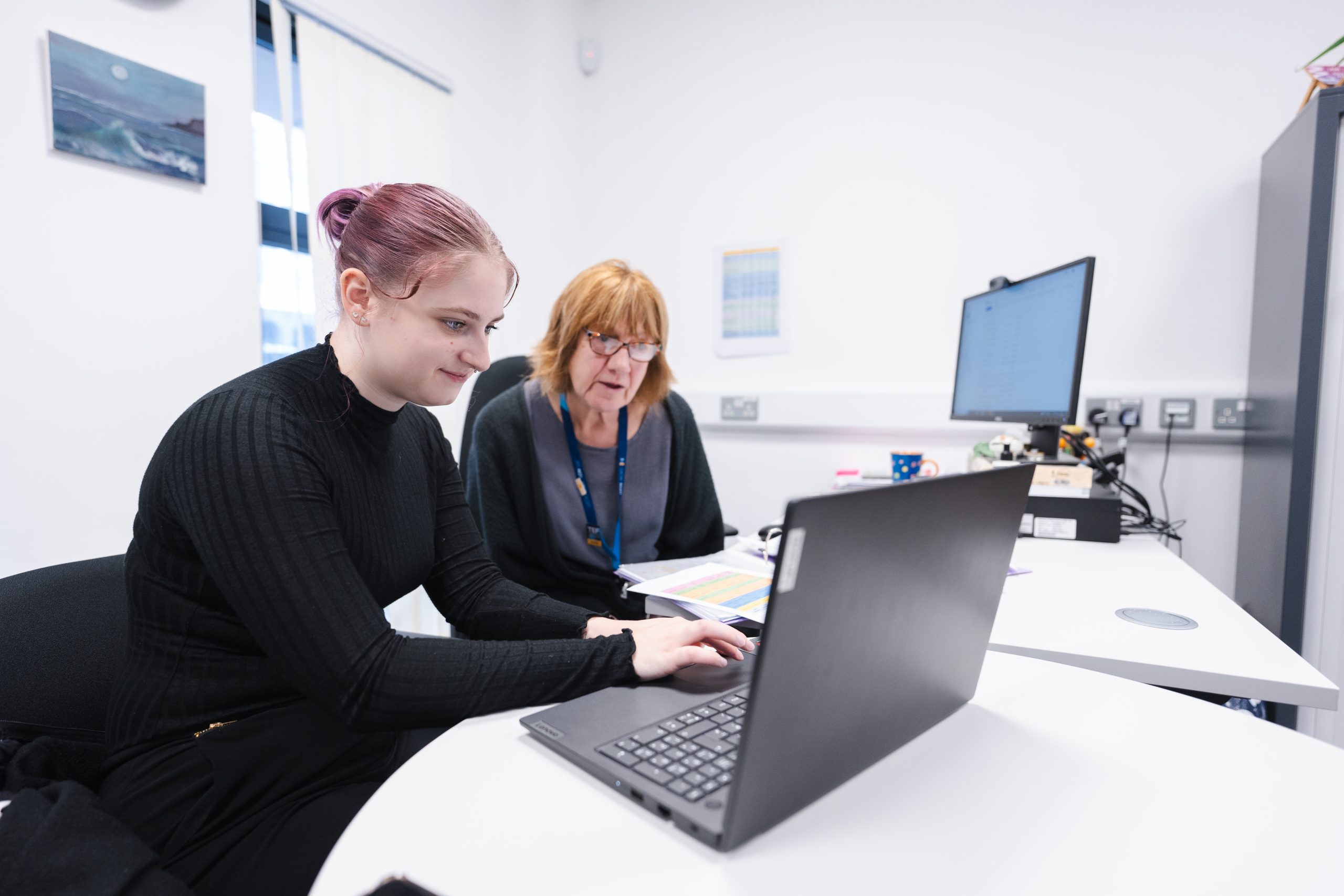 Student and staff on a laptop