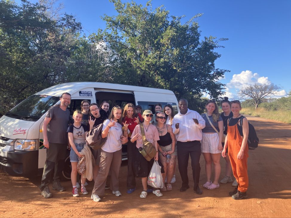 Students posing with a minivan.