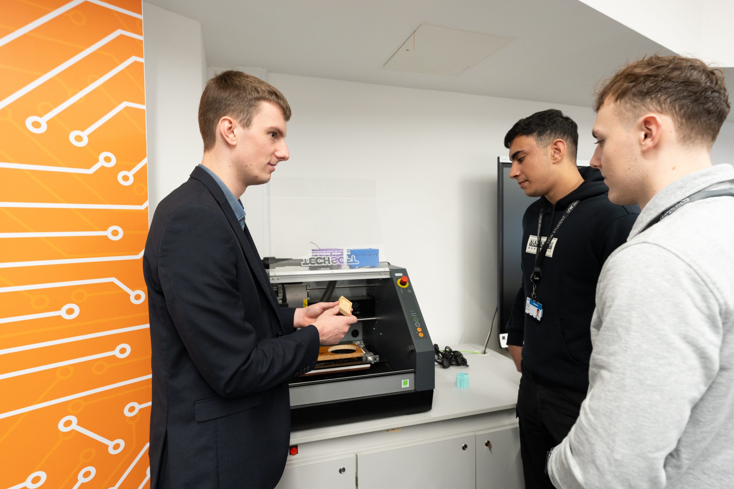 A UCW lecturer explaining his course to two students